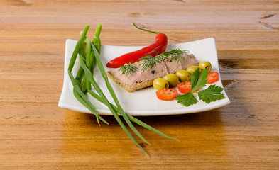 breakfast with a sandwich on a wooden table, white square plate