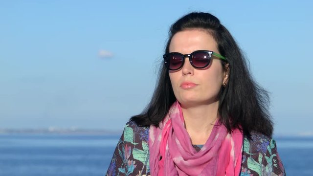 4K Close up shot of a beautiful woman on the sea beackground