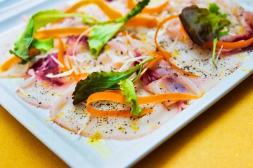 Fresh Sliced raw beef meat with leaf lettuce on the table