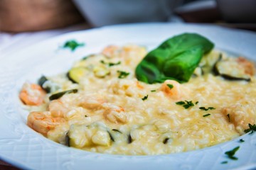 Fototapeta na wymiar Tasty risotto with Shrimp, fresh herbs vegetables on a white plate