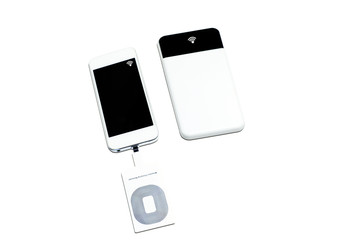 white smartphone with wireless charging receiver tool at charge slot and a sign of wireless charging mode with the power bank on white  background isolated