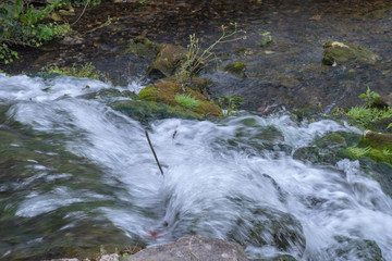 A top down view of a small waterfall. The photographer slowed the motion to capture a milky flowing effect.