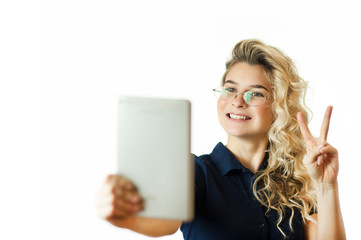 Naklejka premium Happy business woman standing with table computer over background. Wear a blue shirt and glasses. Talking with a gadget