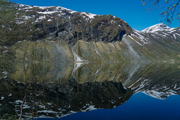 Norway beautiful spring landscape. Mountains reflection in calm water of fjord