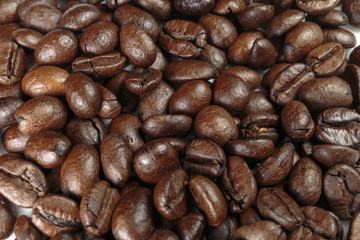 Well-roasted coffee beans background closeup.