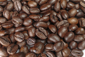 Well-roasted coffee beans background closeup.