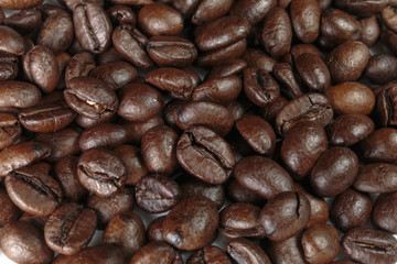Well-roasted coffee beans background closeup.