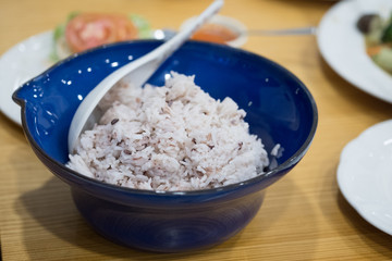 Organic rice on blue bowl, healthy food concept