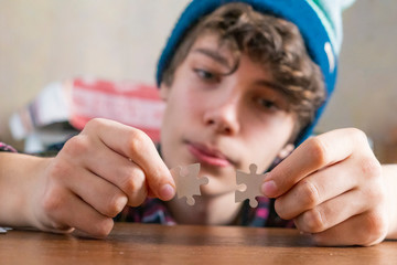 young person hands solving puzzle at the table f
