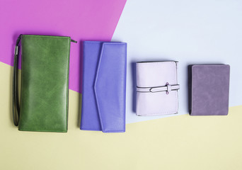 Many leather purses on a colored pastel background. Top View.