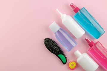 Various hair care products and various hair accessories on a bright pink background. hair cosmetics. top view with space for text