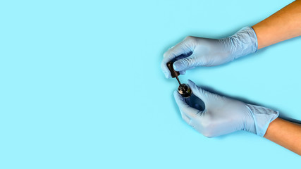 master nails in blue gloves holds nail polish. set of manicure accessories on blue background top...