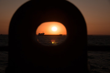 cargo ship outgoing from port at sunrise