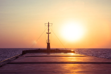Fototapeta na wymiar cargo ship outgoing from port at sunrise