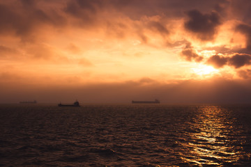 cargo ship outgoing from port at sunrise