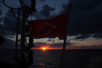 cargo ship outgoing from port at sunrise