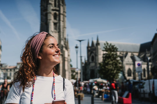 .Young woman doing sightseeing around the beautiful city of Bordeaux in France. Using her smartphone. Travel photography. Lifestyle.
