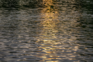 Setting sun reflecting on river water patterns
