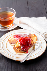 pancakes with berry jam on kitchen table background