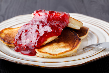 pancakes with berry jam on kitchen table background
