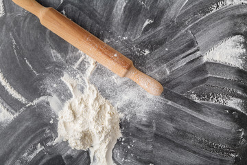 white flour with a rolling pin on a black background