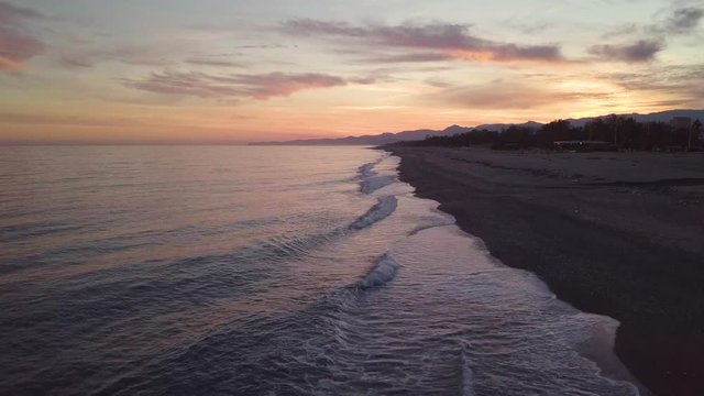 Vista aerea di un tramonto rosso infuocato spettacolare in riva al mare calmo