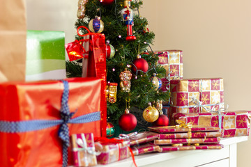 Artificial christmas tree with traditional decorations and many gifts - close up