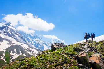 Fototapeta premium Climbers look at rocky summit covered by snow