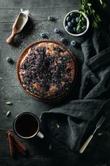 Flat lay with delicious homemade blueberry pie on dark background