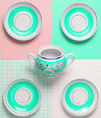 Ceramic saucers and teapots on a creative background, top view.