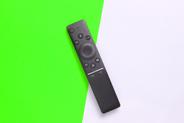 A modern TV remote control on green white background. Top view, minimalism.