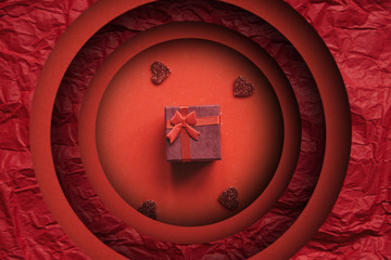 Red box with a gift on a red background. Concept for Valentine's Day or Women's Day or any holiday....