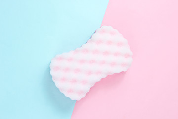 Abrasive sponge on a pink-blue pastel background. Top view