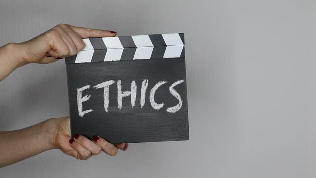 Ethics concept. Female hands holding movie clapper