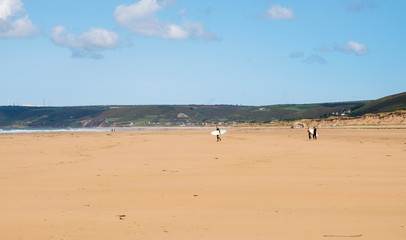Landscape near Biville in Normady. Man and two female friends with surfboards. Second world war bunker on beach. France