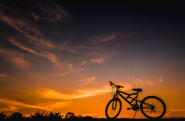 Fototapeta na wymiar Photo of silhouette of profile bike at golden sunset.