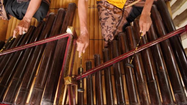 Traditional Balinese Music Instument Gamelan. Asian Musician Man in Traditional Clothes Playing on Bamboo Xylophone at Ceremony in Temple. 4K. Bali, Indonesia.