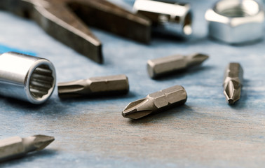 Bits for a screwdriver and socket wrench on wooden background. Close up. 