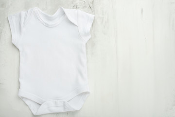 Layout Flat Lay a white baby body shirt on a white marble background. Layout for design and placement of logos, advertising