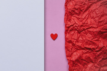 Minimalistic concept for Valentine's Day or another love event. Red small heart on a pink...