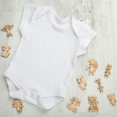 Layout Flat Lay white baby bodysuit shirt, on a white background with children's wooden toys. Mock...