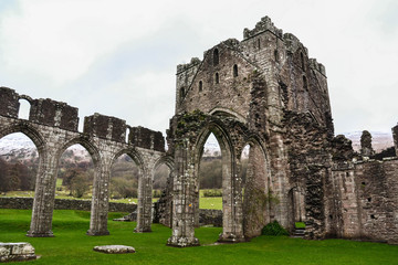 Landmarks of Wales travel concept. View of ancient ruins of the castle/church in Brecon Beacons National Park, United Kingdom. Popular tourist attraction (Llanthony Priory,Hay-on-Wye, Black Mountains)
