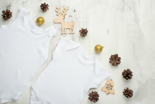 Layout Flat Lay a white baby bodysuit on a white background, with children's wooden toys. Choose design and placement of logos, advertising