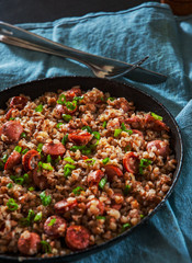 Fried Meat sausages in a frying pan with buckwheat porridge kasha