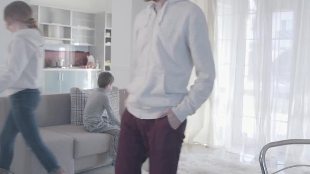 Young parents arguing and disperse to different rooms. Husband angrily looks after the departing wife and swears. Kid is scared and at a loss. Family relationships. Family problems. Slow motion.