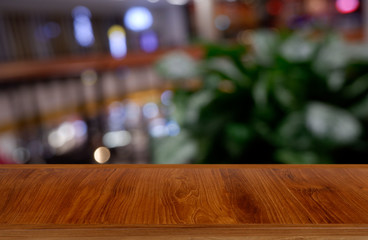 Empty dark wooden table in front of abstract blurred background of restaurant, shopping mall interior. can be used for display or montage your products - Image.