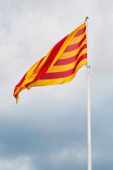 Catalan flag in Barcelona. Catalan flag waving in the wind on the background of the pre-storm sky.