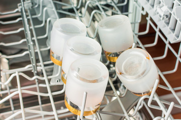 Small glasses of vodka lie in the middle compartment of the dishwasher