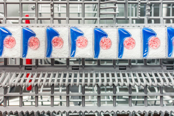 Powder tablets lie on the shelf in the dishwasher