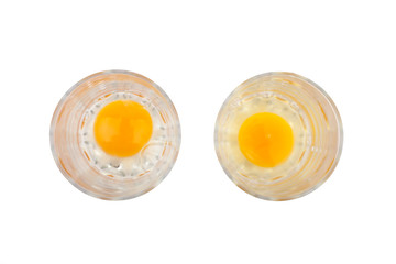 Normal egg in the left glass and bad rotten egg in the right glass, isolated on white background, top view